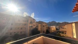 een uitzicht op de zon vanaf het balkon van een gebouw bij Appart 2 Chambres Charley super emplacement et parking in Calvi