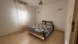 een slaapkamer met een bed in een witte kamer bij Appart 2 Chambres Charley super emplacement et parking in Calvi