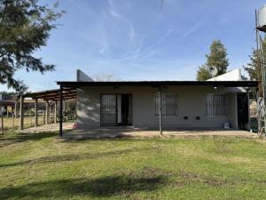 una piccola casa bianca con un prato di Casa Quinta Suipacha a Suipacha