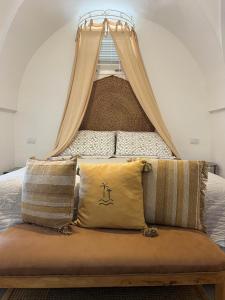 a bed with a canopy and pillows in a room at Dimora Tauro B&B in Fasano