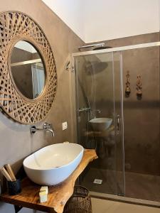 a bathroom with a sink and a mirror and a shower at Dimora Tauro B&B in Fasano