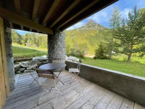 Un patio con una mesa y sillas en una terraza. en Appartement de Standing - ARC 1950 - 4 - 6 à 12 personnes, en Arc 1950