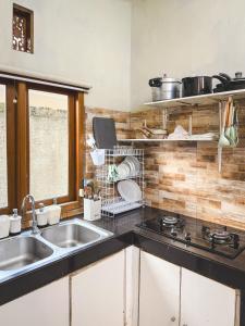 a kitchen with a sink and a stove at Room 2 at Villa Restu 5, King Room, Private Bath in Paragajen