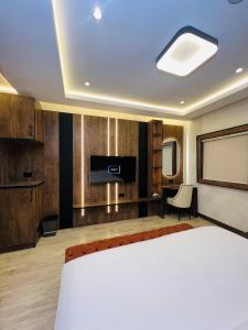 a hotel room with a bed and a flat screen tv at The Westbury Inn in Abuja