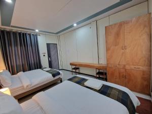a hotel room with two beds and a desk at KL's Coffee & Hostel in Pakse