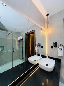 a bathroom with two white sinks and a shower at The Westbury Inn in Abuja