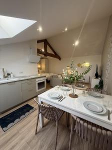 a kitchen and living room with a white table and chairs at Petite Merveille sous les toits in Dijon