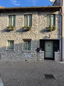 a stone building with windows and plants on it at Ca' Dei Sassi in Segusino
