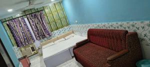 une chaise rouge assise dans une pièce avec fenêtre dans l'établissement Gulshan Cottage, à Mussoorie