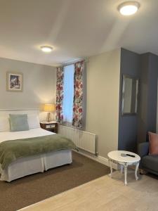 a bedroom with a bed and a table and a couch at Birch Lane Guesthouse in Wexford +4 photos