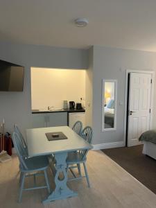 a dining room with a table and chairs and a kitchen at Birch Lane Guesthouse in Wexford