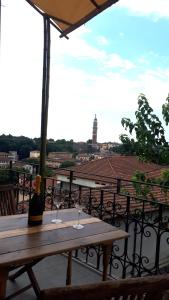 a wooden table with two wine glasses on a balcony at La nuova casa di Giove in Palazzolo sullʼOglio