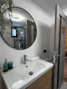 Un baño con un lavabo blanco y un espejo. en SUN by Sun&Moon Cabins, 