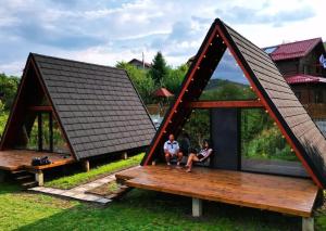 dos personas sentadas en el porche de una casa pequeña en SUN by Sun&Moon Cabins, 