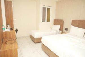 バンガロールにあるHotel Luma Suites-Cottonpetのベッド2台と机があるホテルの部屋