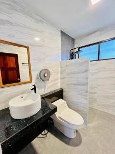 a bathroom with a white toilet and a sink at Lanta Nature House in Ko Lanta