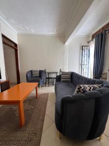 a living room with a couch and a table at Karma Homes in Buye