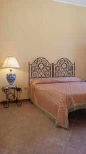 ein Schlafzimmer mit einem Bett und einem Tisch mit einer Lampe in der Unterkunft Sicily Sea House  in Gioiosa Marea
