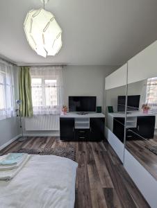 a living room with a large bed and a tv at Apartament spatios, mobilat si utilat complet in Floreşti