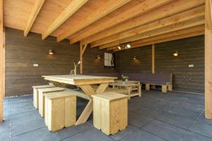 a wooden patio with a wooden table and benches at Kasteel Uylenburght in Rheeze
