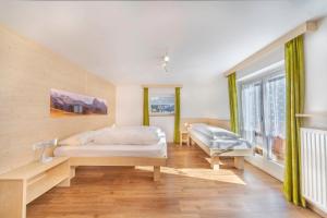 a bedroom with a white bed and a window at Dumbria Dolomites in Selva di Val Gardena