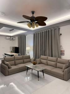 a living room with a couch and a ceiling fan at Fovahi shark view inn in Fuvahmulah
