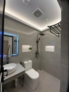 a bathroom with a toilet and a sink at Fovahi shark view inn in Fuvahmulah
