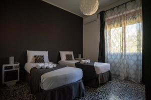 a bedroom with two beds and a window at Casa Scano in Morgongiori