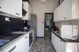 Una cocina con gabinetes blancos y encimeras negras. en Casa Scano, 