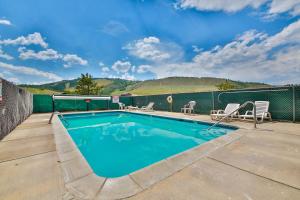 a swimming pool with chairs and a fence at Mountainside 049 in Granby