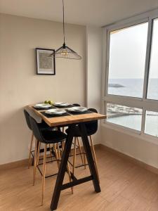 a dining room table with black chairs and a window at Verana House in Arguineguín