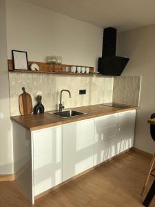 a kitchen with white cabinets and a sink at Verana House in Arguineguín