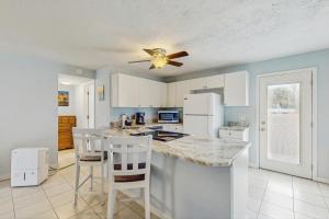 cocina con armarios blancos y ventilador de techo en Blissful Beach Retreat AC, en Punta Gorda Beach