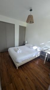 - un lit blanc dans une chambre dotée de parquet dans l'établissement Chambre Privée Lyon Oullins, à Oullins