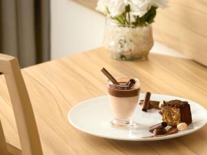 a plate with a drink and a piece of cake on a table at Novotel Cairo Airport in Cairo