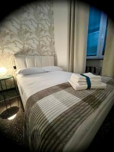 a bedroom with a bed with towels on it at Dimora Soprana - Affittacamere confortevole in Genova