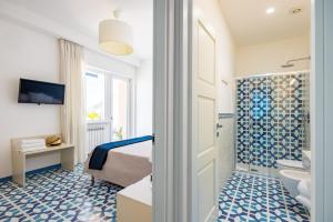 Un dormitorio con una cama y un baño con lavabo. en Blumare Amalfi Coast, en Maiori 36 fotos más