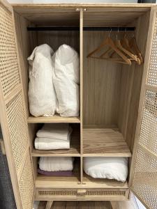 Cocon des Chandeliers في بوردو: خزانة تحتوي على وسائد ومناشف بيضاء