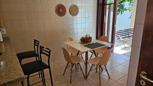 ein Esszimmer mit einem Tisch und Stühlen sowie einem Balkon in der Unterkunft Casa aconchegante e grande no Circuito das Águas Paulista - cem por cento privativa in Amparo