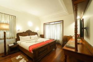 a hotel room with a bed and a window at JC Residency in Kodaikānāl