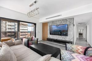 a living room with a couch and a tv at O&O Group-Charming 4BR APT with Stellar Sea View in Bat Yam +33 photos