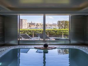 una persona en una piscina en un edificio en Sofitel Marseille Vieux-Port, en Marsella