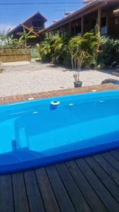 a blue swimming pool in front of a house at Cabanas de Marina in Imbituba +8 photos