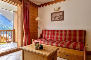 ein Wohnzimmer mit einer Couch und einem Fenster in der Unterkunft Quillis vue Montagne, Spa & Terrasse in Champagny-en-Vanoise