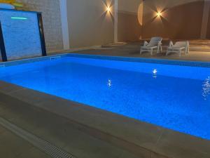 a swimming pool with blue water in a room at Dar El Oualidine belle villa familiale avec piscine privée sans vis a vis  +4 photos
