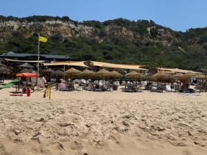 a beach with many chairs and umbrellas on it at Beach Bum Caravan in Caparica +33 photos
