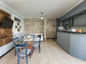 a kitchen and living room with a table and chairs at Apartamento no Centro para Casal in Serra Negra
