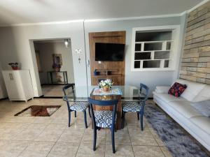 a living room with a table and a couch at Apartamento no Centro para Casal in Serra Negra