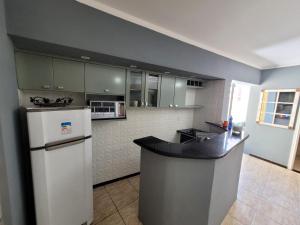 a kitchen with a white refrigerator and a counter at Apartamento no Centro para Casal in Serra Negra +1 photo
