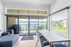 a living room with a table and chairs and a large window at Lake Chelan Shores - Beachfront Sunsets #6-5 in Chelan
